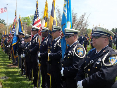 line of police officers stand with flags